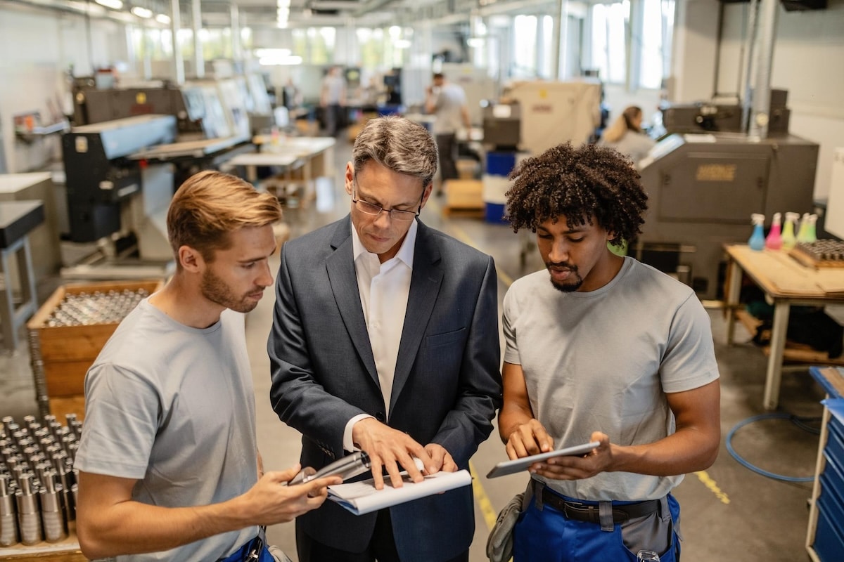 mid-adult-engineer-two-steel-workers-going-through-quality-reports-while-working-industrial-building