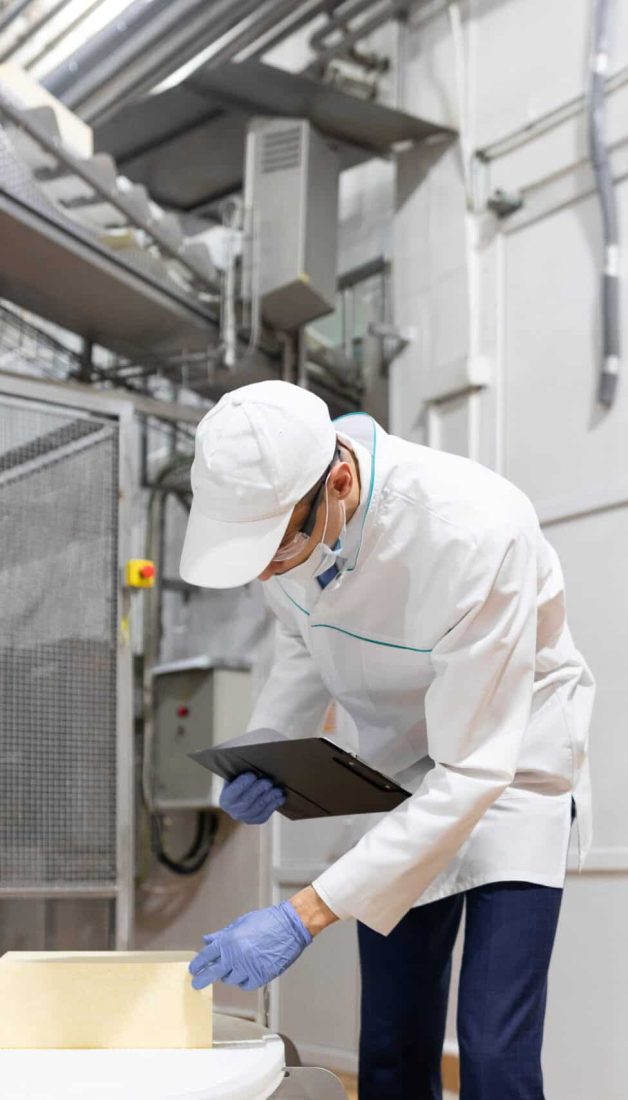 technologist make set up of the production line while standing near digital screen at the department of dairy factory